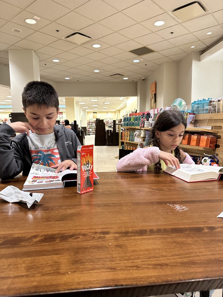 Two siblings reading at a bookstore